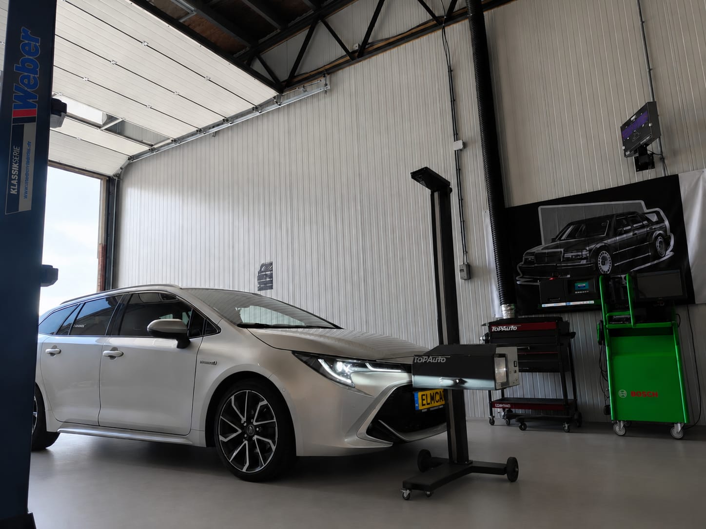 ELMCARS werkplaats met witte auto en meetapparatuur